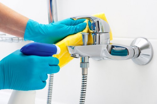 Technician treating upholstered furniture with specialist cleaning equipment