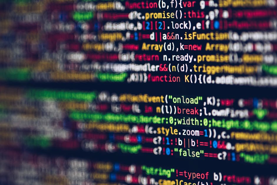 Close-up of a computer screen displaying lines of colourful programming code, with syntax highlighted in green, orange, purple, and blue on a black background. The code appears to be part of a softwar
